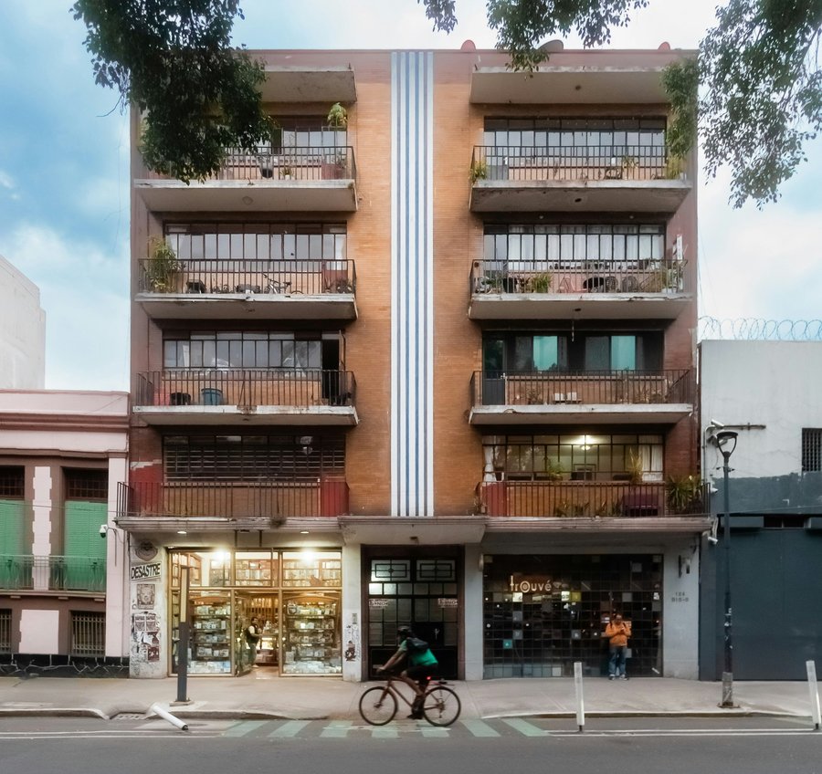 low rise apartments over store with cyclist in front